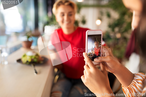 Image of women having lunch and photographing at cafe