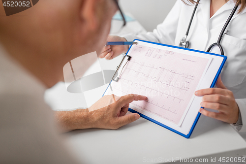 Image of senior man and doctor with cardiogram at hospital