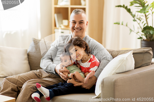 Image of happy father with preteen and baby son at home