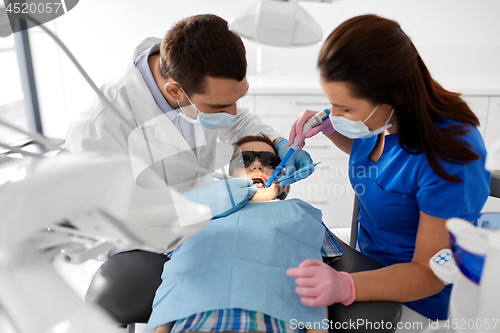 Image of dentist treating kid teeth at dental clinic