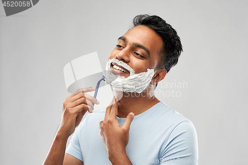 Image of indian man shaving beard with razor blade