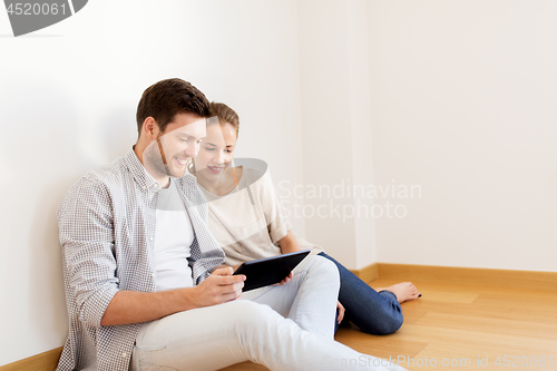 Image of happy couple with tablet pc computer at new home