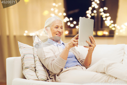 Image of senior woman with tablet computer on christmas