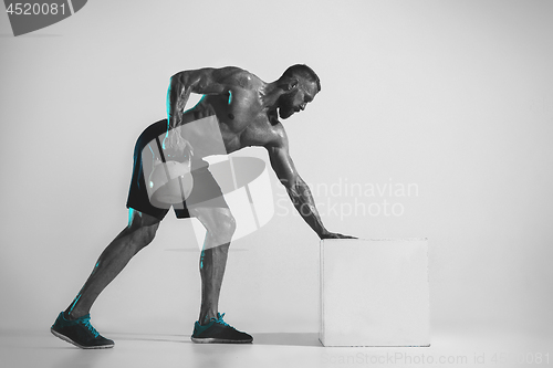 Image of Young caucasian bodybuilder training over studio background