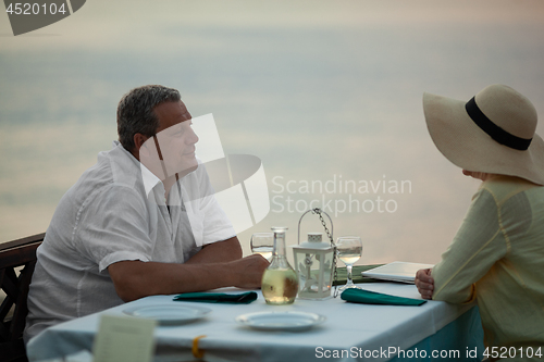 Image of Romantic evening for mature couple in the seafront restaurant