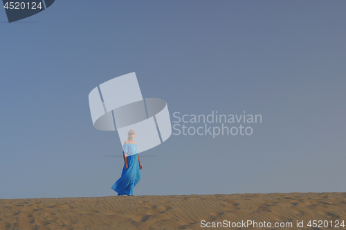 Image of Woman in blue dress against the sky
