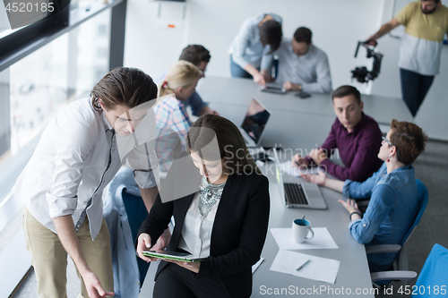 Image of Two Business People Working With Tablet in office
