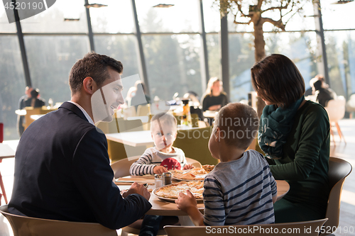 Image of Young parents enjoying lunch time with their children