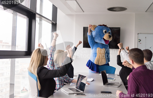 Image of boss dresed as bear having fun with business people in trendy of