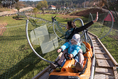 Image of mother and son enjoys driving on alpine coaster