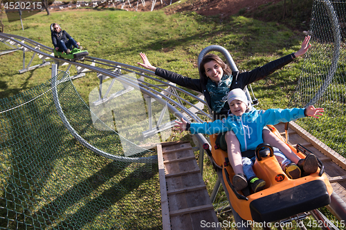 Image of mother and son enjoys driving on alpine coaster