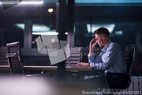 Image of man working on laptop in dark office