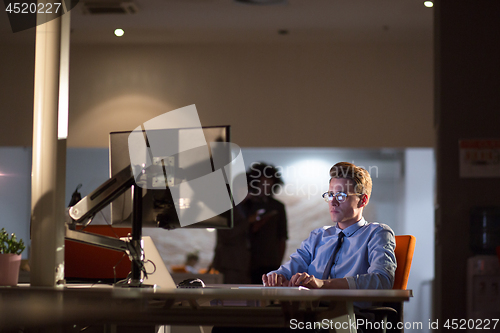 Image of man working on computer in dark office