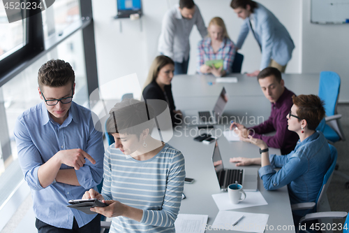 Image of Two Business People Working With Tablet in office