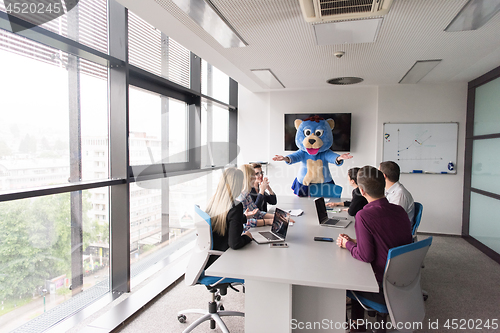 Image of boss dresed as bear having fun with business people in trendy of