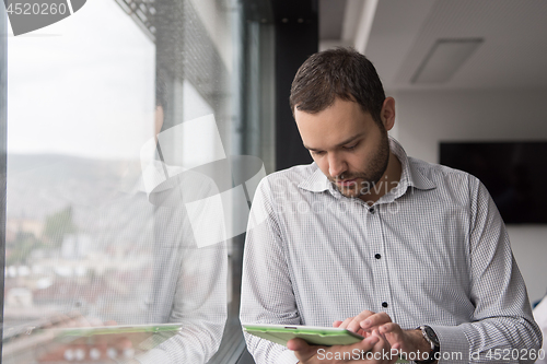 Image of Businessman Using Tablet In Office Building by window