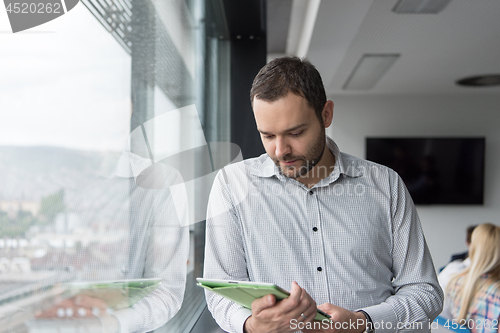 Image of Businessman Using Tablet In Office Building by window