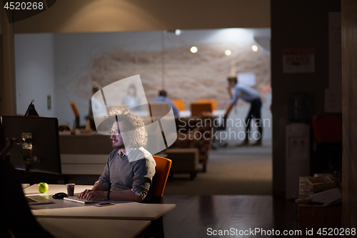 Image of man working on computer in dark office