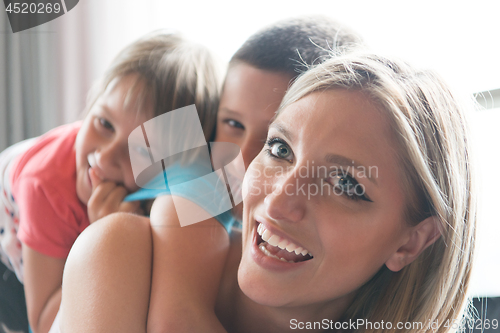 Image of young mother spending time with kids on the floor