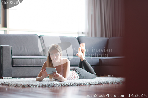 Image of young women using tablet computer on the floor