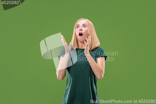 Image of Beautiful woman looking suprised isolated on green