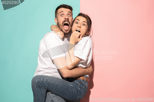 Image of Portrait of the scared man and woman on pink and blue