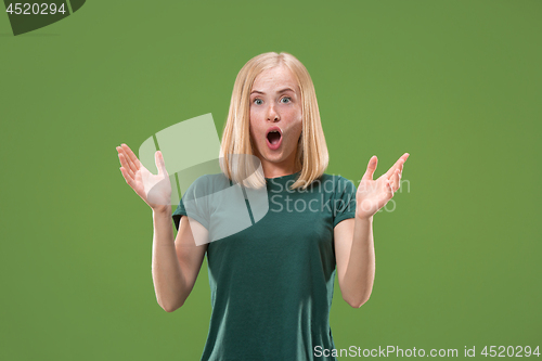 Image of Beautiful woman looking suprised isolated on green