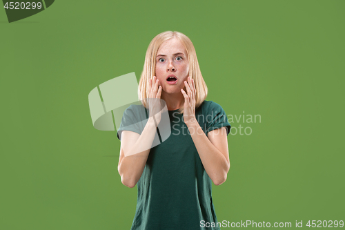 Image of Beautiful woman looking suprised isolated on green