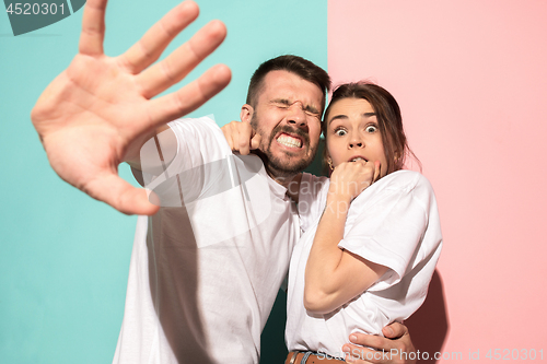 Image of Portrait of the scared man and woman on pink and blue