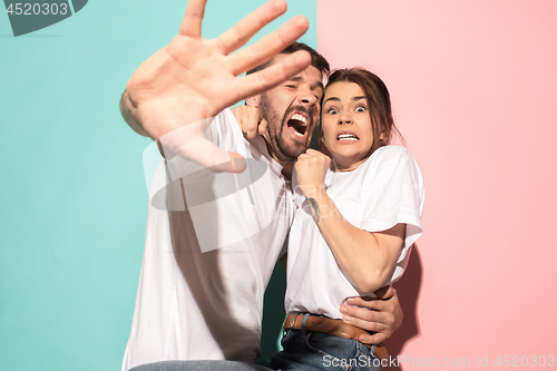 Image of Portrait of the scared man and woman on pink and blue