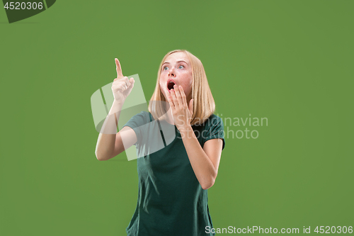 Image of Beautiful woman looking suprised isolated on green