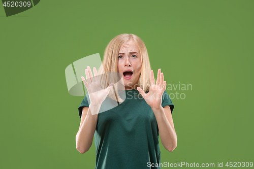 Image of Portrait of the scared woman on green
