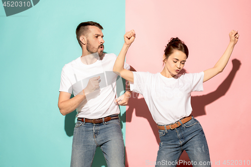 Image of A couple of young man and woman dancing hip-hop at studio.