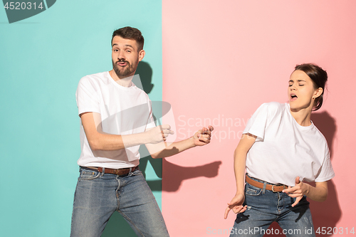 Image of A couple of young man and woman dancing hip-hop at studio.