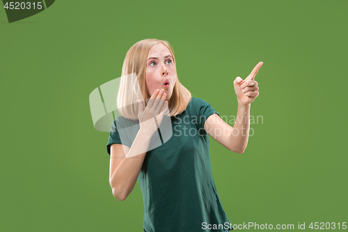 Image of Beautiful woman looking suprised isolated on green