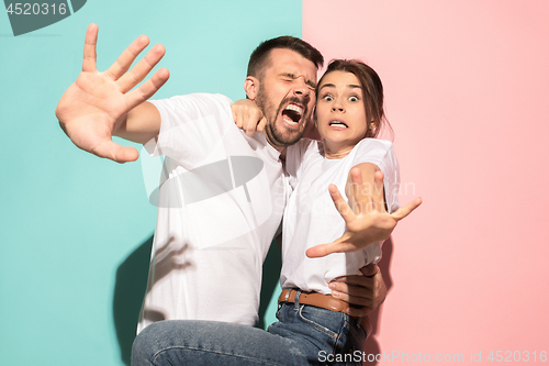 Image of Portrait of the scared man and woman on pink and blue