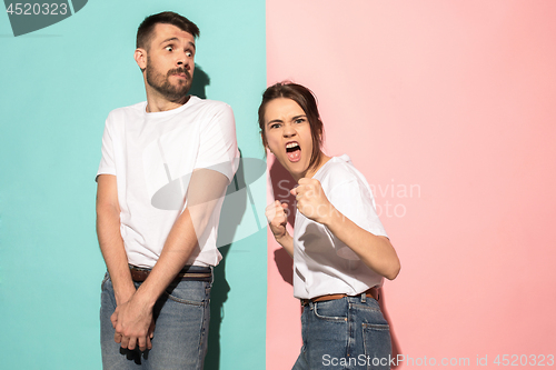 Image of The young emotional angry woman on pink studio background