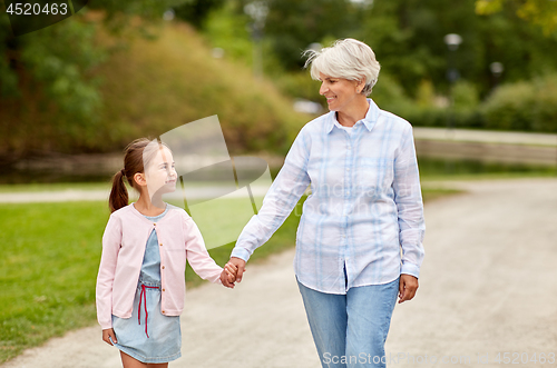 Image of grandmother and granddaughter walking at park