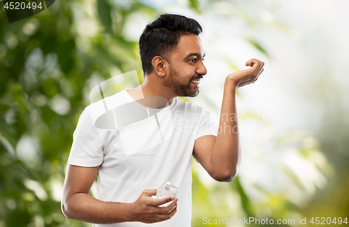 Image of happy indian man with perfume