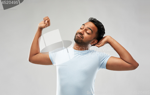 Image of indian man stretching over grey background