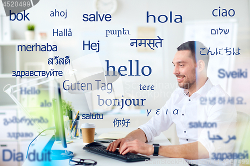 Image of man with computer over words in foreign languages