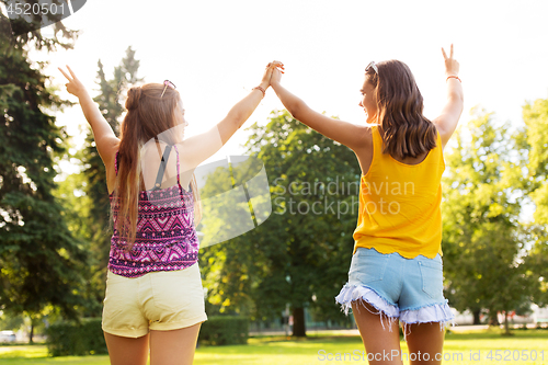 Image of teenage girls showing peace hand sign at park