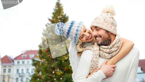 Image of happy couple hugging over christmas tree