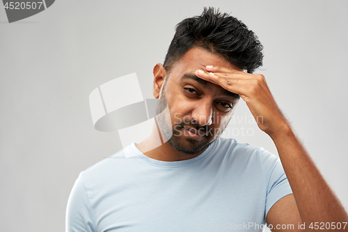 Image of unhappy indian man suffering from headache