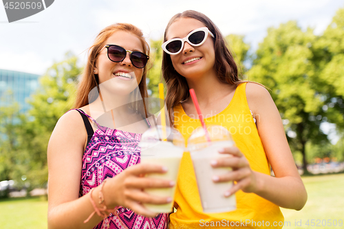 Image of teenage girls with milk shakes at summer park