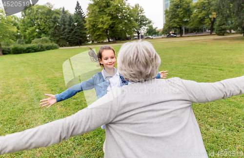 Image of grandmother and granddaughter playing at park