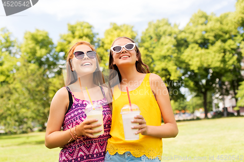 Image of teenage girls with milk shakes at summer park