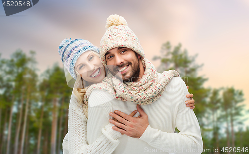 Image of couple hugging over winter forest background