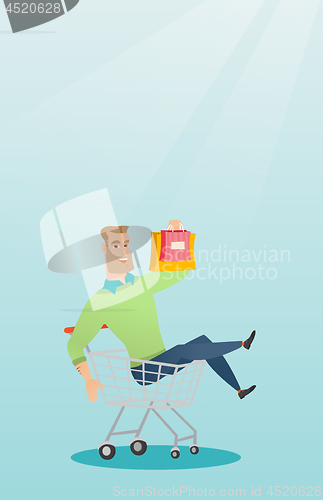 Image of Young caucasian man riding in shopping trolley.