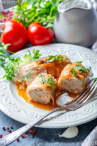 Image of Cabbage rolls stuffed with ground beef and rice.